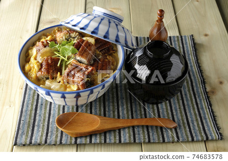 在餐墊上放上鰻魚片的鰻魚碗，一套湯和一把木勺 74683578