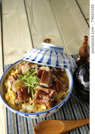 An eel bowl with eel kabayaki on a place mat, a set of soup and a wooden spoon 74683588