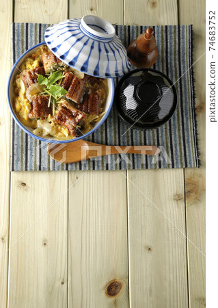 鳥瞰的一套鰻魚碗，湯和木勺鰻魚片在餐墊上 74683752