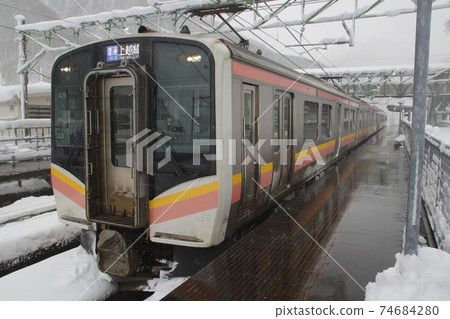 Joetsu Line E129 series stopped at Tsuchitaru Station in winter 74684280