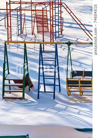 Children's playground in snowdrifts 74684818