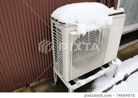 Outdoor unit of air conditioner covered with snow Outdoor unit of air conditioner covered with snow 74684978