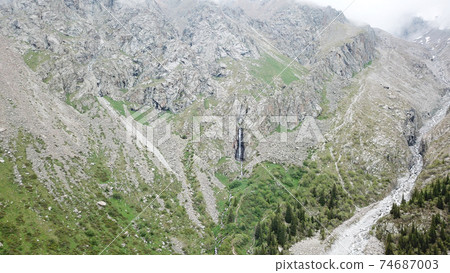 High waterfall among the rocks. View from a drone. High waterfall among the rocks. View from a drone. 74687003