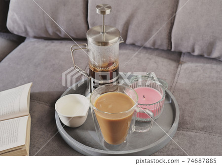 morning cup of coffee with milk and scented soy candle 74687885