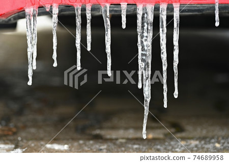Beautiful icicles on the car. Concept for winter and dangerous winter traffic of cars on the road. 74689958