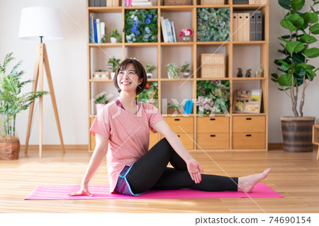 Young woman doing yoga poses in the living room 74690154
