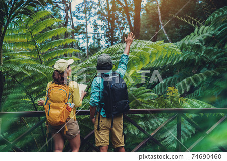 Asian couple travel nature walking relax and studying nature in the fores... Asian couple travel nature walking relax and studying nature in the fores... 74690460