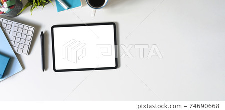 Top view image of workspace is surrounding by white screen tablet and office equipment. 74690668