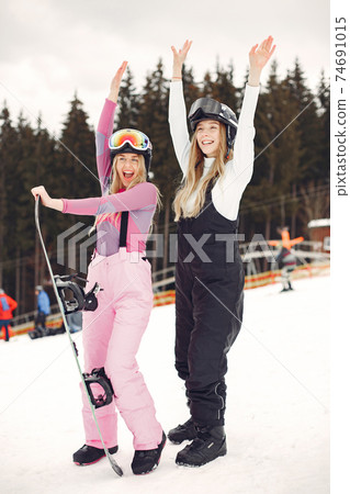 Girls snowboarding in the mountains with the snowboard Girls snowboarding in the mountains with the snowboard 74691015