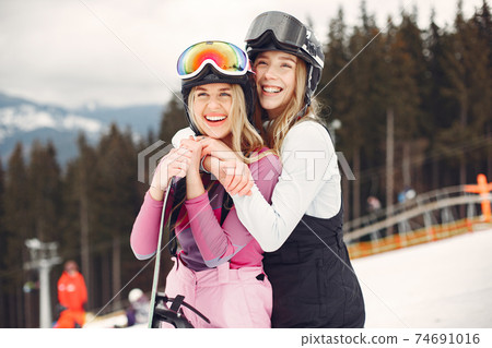 Girls snowboarding in the mountains with the snowboard Girls snowboarding in the mountains with the snowboard 74691016