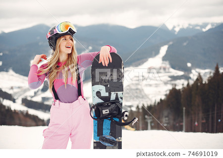 Girl snowboarding in the mountains with the snowboard Girl snowboarding in the mountains with the snowboard 74691019
