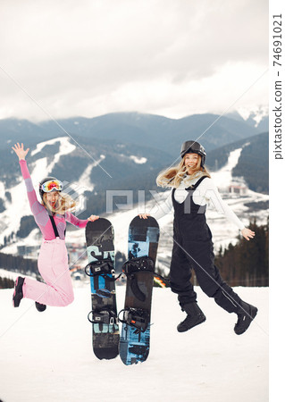 Girls snowboarding in the mountains with the snowboard 74691021