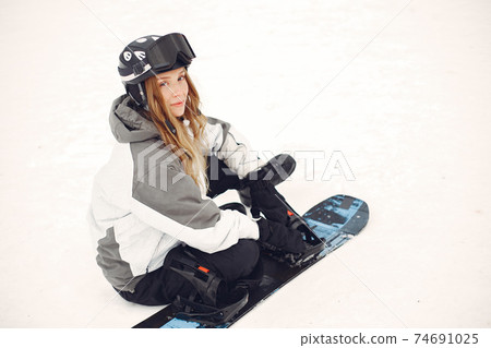 Girl snowboarding in the mountains with the snowboard Girl snowboarding in the mountains with the snowboard 74691025