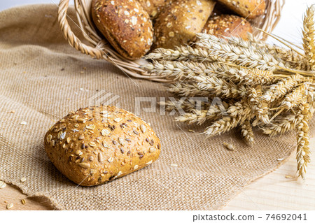 Loaf bread. Rye bakery with crusty loaves and crumbs. Fresh loaf of rustic traditional bread with wheat grain ear or spike plant on natural cotton background. Bio ingredients, very healthy seeds. 74692041