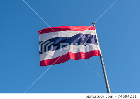 Thailand flag with blue sky as background Thailand flag with blue sky as background 74694211