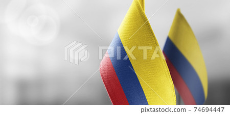Small national flags of the Colombia on a light blurry background 74694447