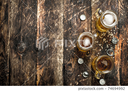 Fresh beer in a glass with stoppers and a bottle opener. Fresh beer in a glass with stoppers and a bottle opener. 74694992