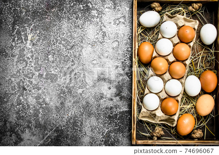 Fresh chicken eggs on an old tray. 74696067