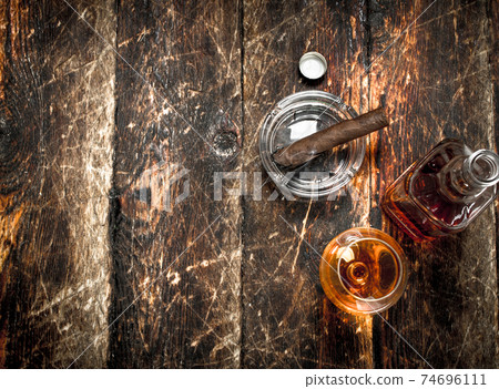 French cognac with a smoking cigar. French cognac with a smoking cigar. 74696111