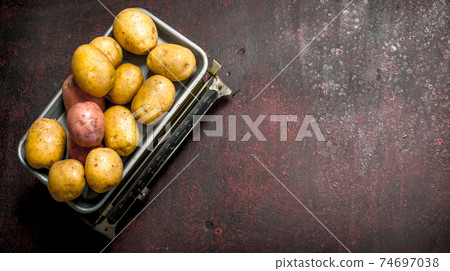 fresh potatoes on the scales. fresh potatoes on the scales. 74697038