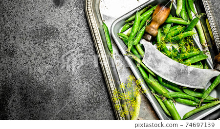 Green peas with an old knife. 74697139