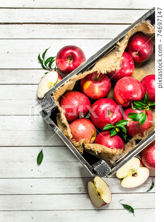 Red apples in a box. 74697147