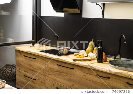 Oak kitchen worktop on kitchen with a sink, cookstove and food ingredients, bottle and kitchen facilities. Practical using of wooden worktop. Modern interior. Cooking. Oak kitchen worktop on kitchen with a sink, cookstove and food ingredients, bottle and kitchen facilities. Practical using of wooden worktop. Modern interior. Cooking. 74697256