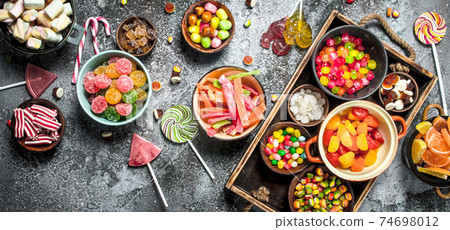 sweets candy, candied fruits with marshmallow and jelly on a wooden tray. sweets candy, candied fruits with marshmallow and jelly on a wooden tray. 74698012