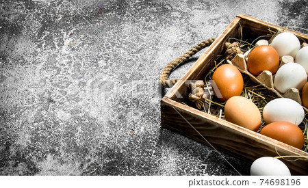 Fresh chicken eggs on an old tray. Fresh chicken eggs on an old tray. 74698196
