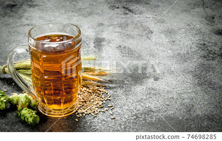 glass of fresh beer. On rustic background. glass of fresh beer. On rustic background. 74698285