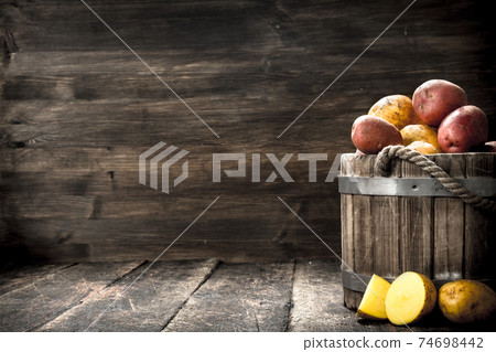 Fresh potatoes in a wooden bucket. 74698442