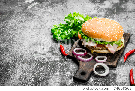 Hot burger with beef, vegetables and chili peppers. Hot burger with beef, vegetables and chili peppers. 74698565