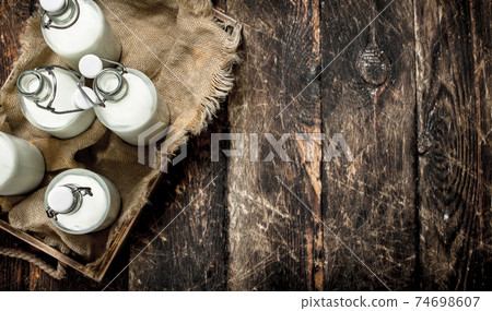 Bottles with fresh milk in a box. Bottles with fresh milk in a box. 74698607