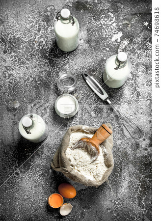 Baking background. Flour with fresh milk in bottles, sour cream and eggs. Baking background. Flour with fresh milk in bottles, sour cream and eggs. 74698618