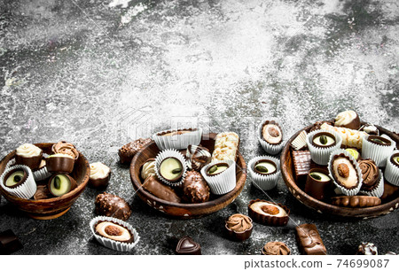 Chocolate candies in a bowls. 74699087