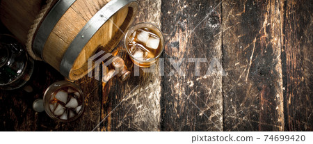 barrel of Scotch whiskey with a glass. 74699420