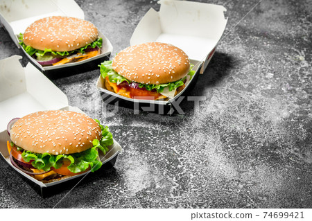 Fresh burgers in paper boxes. 74699421