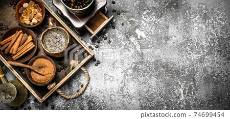Coffee background. Welded coffee in a Turkish with sugar, cinnamon and coffee beans. Coffee background. Welded coffee in a Turkish with sugar, cinnamon and coffee beans. 74699454