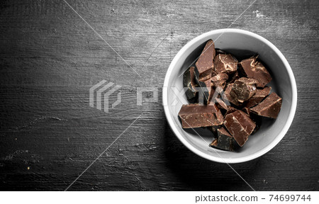Chunks of chocolate in a bowl. 74699744