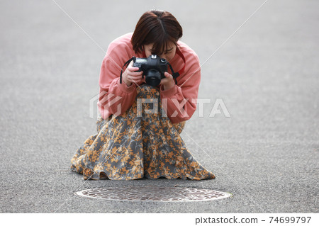 Woman shooting a manhole Woman shooting a manhole 74699797