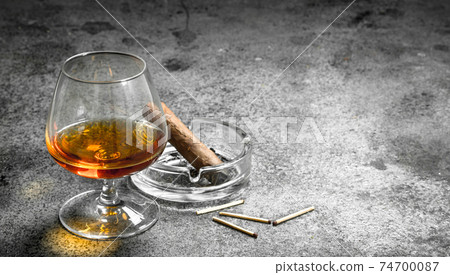 glass of cognac with a cigar. 74700087