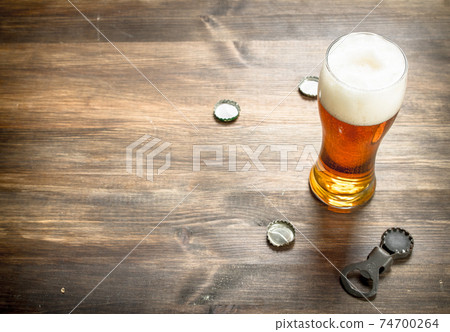 glass of beer with stoppers and a bottle opener. 74700264