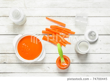 Baby food. Baby carrot puree with milk in a bottle. 74700445