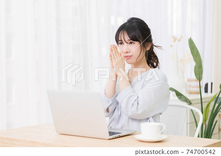 一個年輕女子在房間裡使用筆記本電腦時發出請求的手勢 74700542