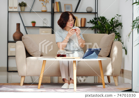 Senior woman watching movie online Senior woman watching movie online 74701030