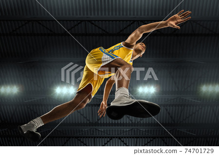 Young professional basketball player in action, motion isolated on black background, look from the bottom. Concept of sport, movement, energy and dynamic. Young professional basketball player in action, motion isolated on black background, look from the bottom. Concept of sport, movement, energy and dynamic. 74701729