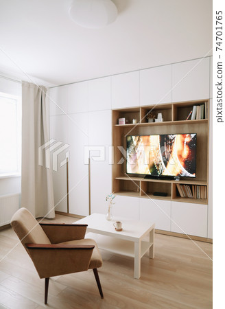 Stylish modern living room interior design with TV, armchair, coffee table and a window with curtains. Stylish modern living room interior design with TV, armchair, coffee table and a window with curtains. 74701765