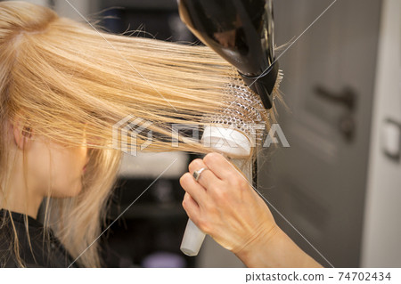 Hand drying hair of woman Hand drying hair of woman 74702434
