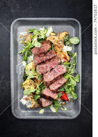 Italian tagliata di manzo with lamb salad with dry aged sliced roast beef  74702617