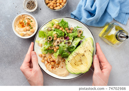 Female hands holding salad bowl 74702986